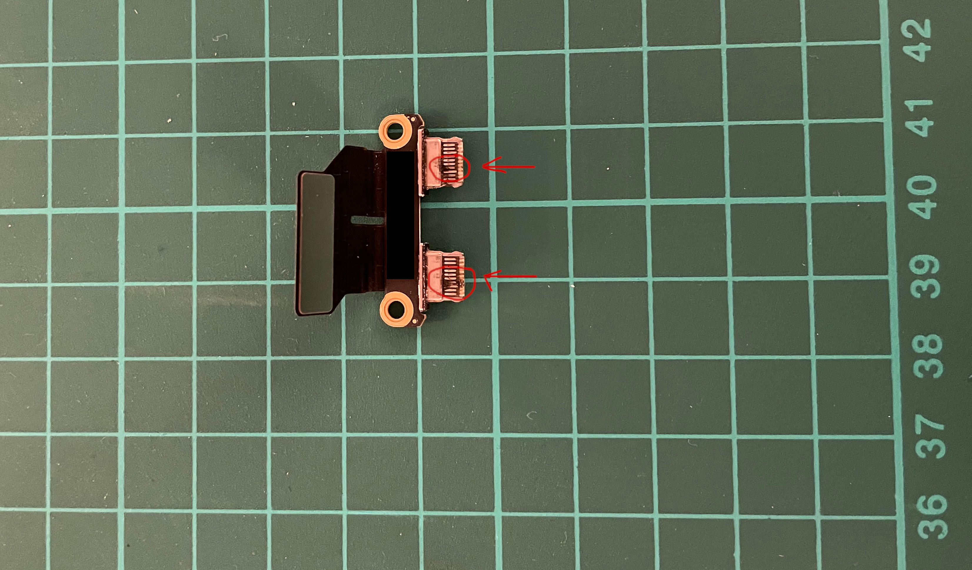 The broken Apple MacBook Air USB-C board you can see the burnt parts of the board USB-C connector. by Tobias Lieshoff