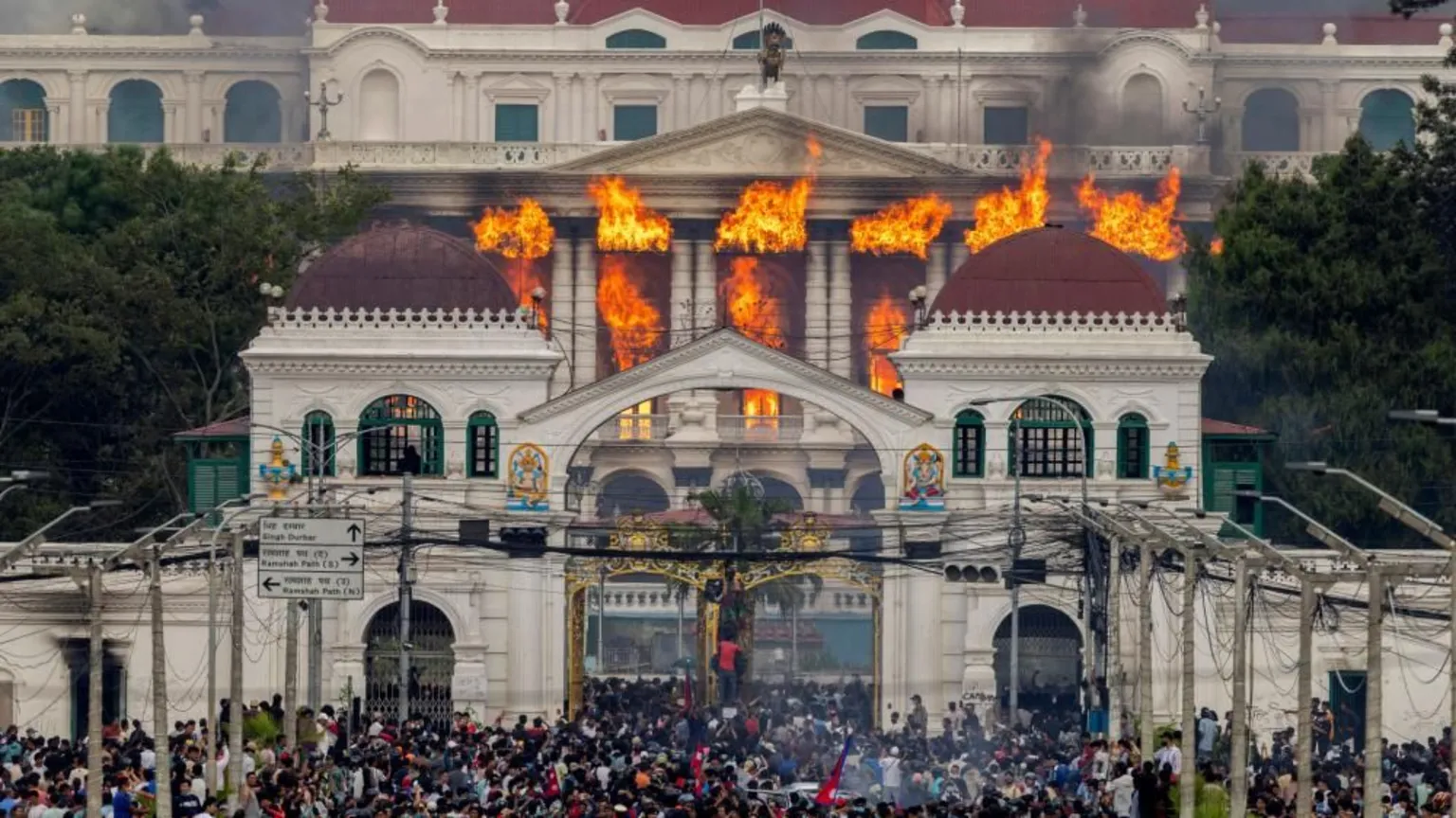 Crowds outside a burning government building.